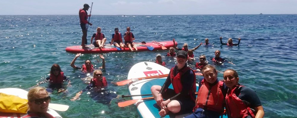 groups of people on big sup boards